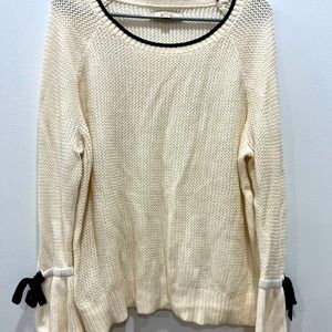 Worn once - cream sweater with trumpet sleeves and black bows at the cuffs.